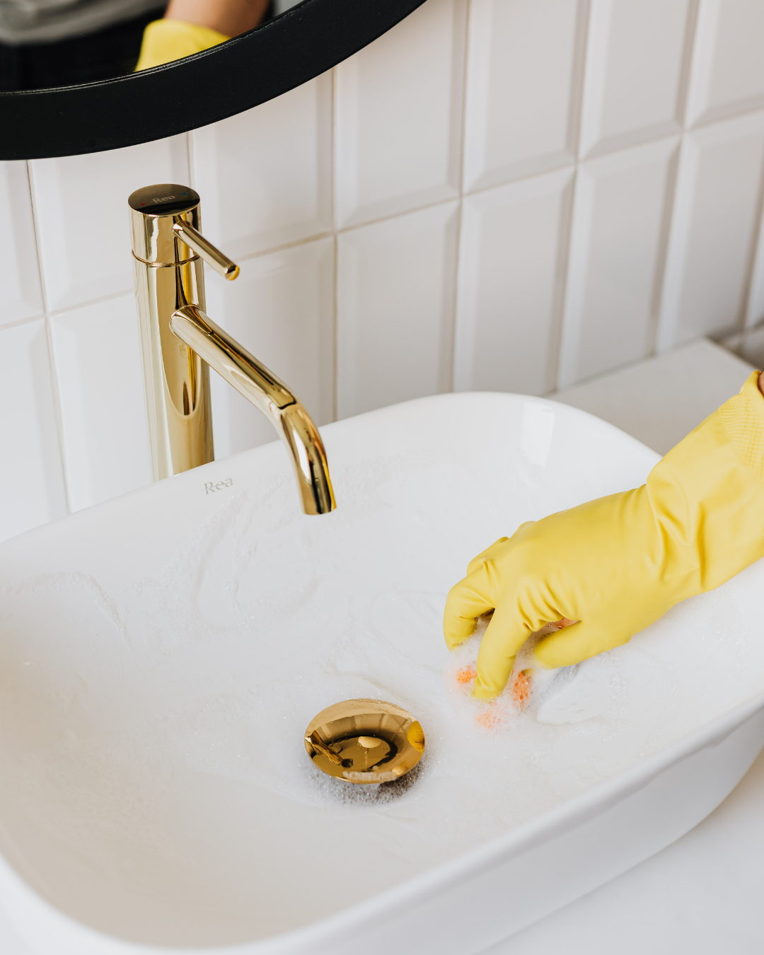 Professional cleaner polishing a bathroom sink